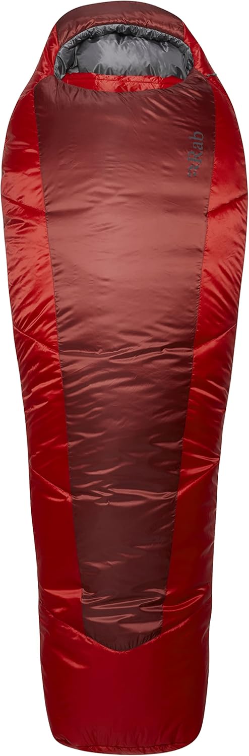 Sac de couchage Rab Sarcophage roulé dans son filet de compression à côté d'un sac à dos de randonnée